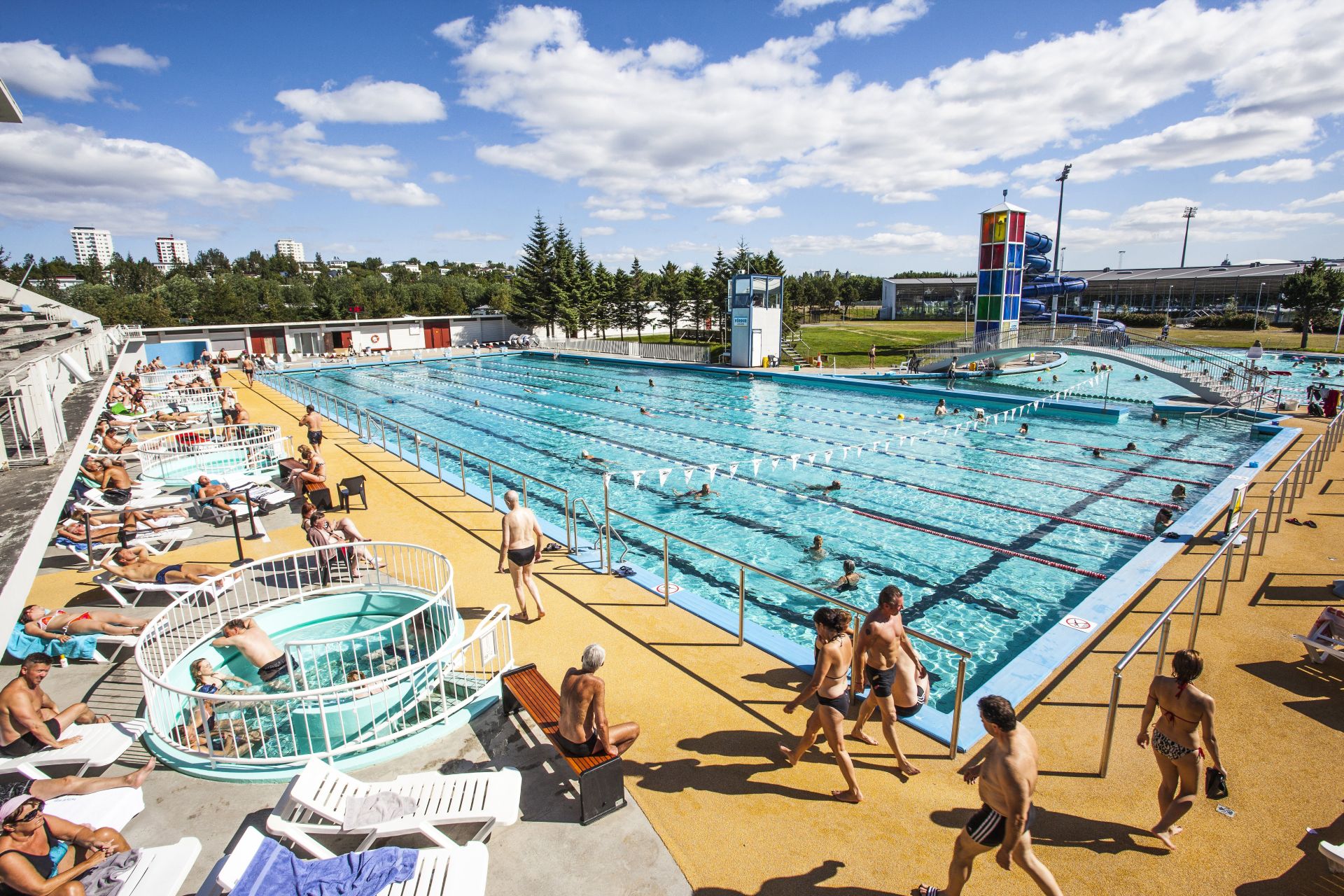 Outdoor geothermal pools at Laugardalslaug with steam rising from blue water